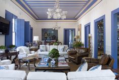 a living room filled with furniture and a chandelier hanging from the skylight