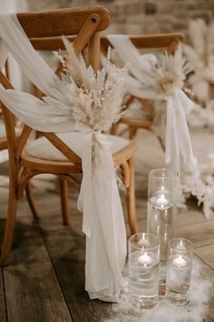 a chair and some candles on a wooden floor with white draping around it