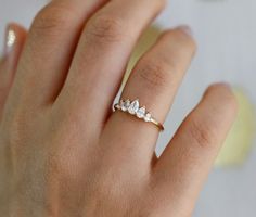 a woman's hand with a diamond ring on top of her finger and the other hand holding it