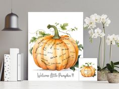 there is a card with a pumpkin on it and some flowers in the vase next to it