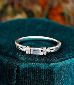 a diamond ring sitting on top of a velvet cushion