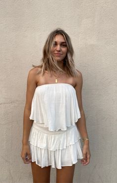 The Monaco White Strapless Romper is a vacay dream! White woven rayon fabric falls from a strapless neckline, with no-slip strips, to a flowy, ruffle overlay bodice with an on-trend smocked overlap back detail. Attached shorts complete the look. Strapless Tube Top With Smocked Back For Summer, Strapless Smocked Back Tube Top For Summer, Strapless Summer Tube Top With Smocked Back, Summer Strapless Tube Top With Smocked Back, Summer Bandeau Tube Top With Smocked Back, Strapless Beach Tube Top With Smocked Back, Strapless Tube Top With Smocked Back For Beach, Off-shoulder Tube Top With Smocked Back For Summer, Off-shoulder Smocked Back Tube Top For Summer