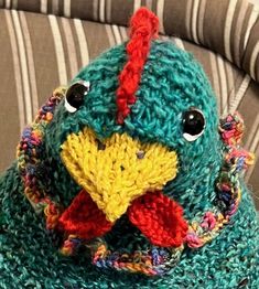 a crocheted stuffed bird sitting on top of a couch