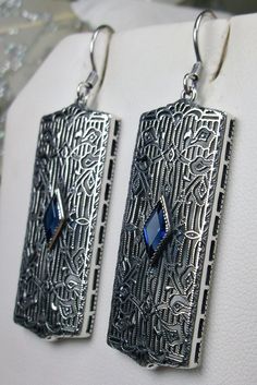 Rectangle Art Deco style earrings with fine lace filigree and a diamond shaped blue sapphire gemstone in the center of the lace filigree field, traditional shepherd hook style ear wire closures Art Deco Sterling Silver Filigree Jewelry, Silver Engraved Art Deco Jewelry, Art Deco Engraved Silver Jewelry, Art Deco Silver Filigree Jewelry, Victorian Engraved Drop Earrings, Silver Filigree Jewelry For Evening, Filigree Metal Earrings For Anniversary, Vintage Sterling Silver Dangle Plug Earrings, Evening Jewelry In Sterling Silver With Intricate Design