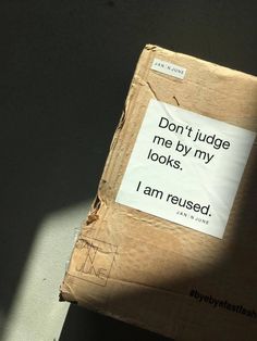 a piece of cardboard with a sign on it that says don't judge me by my looks i am reused