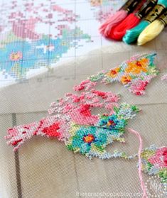 cross - stitching supplies are laid out on a table with the needle and thread