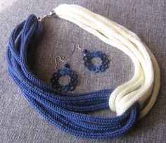 a necklace and earring set with blue beads on a gray cloth covered tablecloth