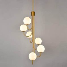 a chandelier with five lights hanging from it's sides and four balls on each side