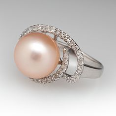 This beautiful ring is centered with one (1), post set, cultured saltwater pearl. The pearl is bordered with forty-five (45), prong set, round single cut diamonds. The ring measures 13.8mm at the top, rises 11.4mm above the finger, tapering to 2.1mm wide and 0.8mm thick at the base of the shank. This ring is currently a size 5. Formal Brilliant Cut Pearl Ring, Classic Pearl Ring With Single Cut Diamonds For Gift, Classic Pearl Ring With Single Cut Diamonds As Gift, Timeless Pearl Ring With Prong Setting For Formal Occasions, Formal Pearl Ring With Diamond In Round Cut, Classic Pearl Ring With Diamonds For Gifts, Elegant Pearl Ring With Diamond Center Stone, Timeless Formal Pearl Ring With Prong Setting, Formal Diamond Pearl Ring With Round Cut