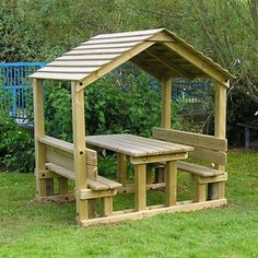 a wooden picnic table and bench in the grass