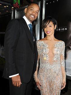 a man and woman standing next to each other on a red carpet at an event