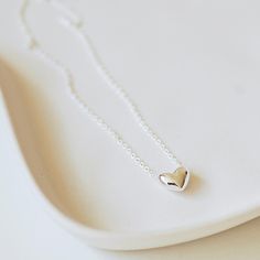 A pretty silver heart on a delicate chain, this stunning necklace is sure to become a jewellery box favourite. Made from sterling silver, it can be worn every day and dressed up or down depending on the occasion. The perfect present for someone special, your necklace will arrive in a Carriage Trade gift box free of charge. The necklace, made from sterling silver, is nickel free and measures 17" (43cm) with a 3cm extension chain. Tiny Silver Necklaces For Mother's Day, Tiny Silver Necklace For Mother's Day, Minimalist Necklace With Heart Pendant Detail, Tiny Silver Charm Necklaces As Gift For Her, Delicate Silver Charm Necklaces For Gift, Simple Necklace With Heart Charm As A Gift, Tiny Silver Charm Necklace As Gift For Her, Tiny Sterling Silver Charm Necklace For Her, Simple Silver Heart Necklace For Valentine's Day