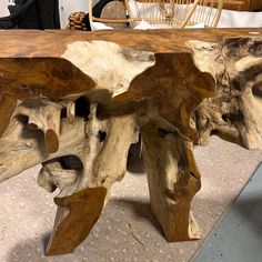 a wooden table made out of logs on top of a rug