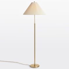 a floor lamp with a white shade on the base and a cord attached to it