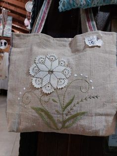 a handbag with flowers on it hanging from a rack