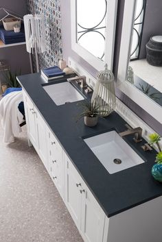 a bathroom with double sinks and mirrors in the wall above it is decorated with plants