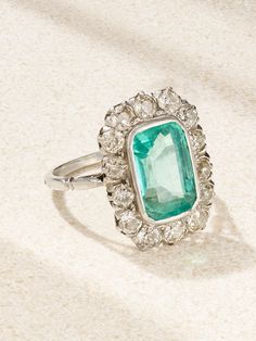 Part of Stephanie Windsor's beautifully curated collection of vintage treasures, this ring dates back to 1915, making it a rare collector's item. It's crafted from platinum and centered with a 2.20-carat Colombian emerald framed by a halo of old European-cut diamonds. Barely visible scratches tell a story of the fingers it's graced and the lives its lived through. Art Deco Emerald Ring Vintage, Vintage White Gold Oval Emerald Ring, Vintage Oval White Gold Emerald Ring, Vintage Oval Emerald Ring In White Gold, Antique Emerald Diamond Ring For Formal Occasions, Gia Certified Art Deco Platinum Jewelry, Antique Platinum Gemstone Rings, Vintage Green Emerald Ring Gia Certified, Antique Platinum Ring With Gemstone