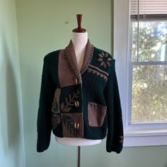 This vintage Sandy Starkman cardigan sweater is a size medium. This cardigan is green with brown leather and wood buttons down the front. It's 40% leather, 60% knit acrylic and dry clean only. This gem has twee western vibes and is in good vintage condition.   Flaws  The leather has some fading and some damage on one shoulder. Also the acrylic has some pilling. Note: All vintage items are going to have signs of wear. I do my best to inspect the items and take note of any flaws, but sometimes thi Vintage Brown Winter Cardigan, Vintage Brown Cardigan For Winter, Vintage Brown Wool Cardigan, Green Vintage Cardigan With Buttons, Vintage Green Cardigan With Button Closure, Vintage Brown Sweater With Button Closure, Vintage Brown Cardigan With Buttons, Vintage Brown Cardigan With Button Closure, Vintage Green Cardigan For Fall