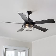 a ceiling fan in a white room with a light on the ceiling and two windows