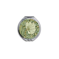 a compact mirror with an image of a flower and leaves on the front, in green