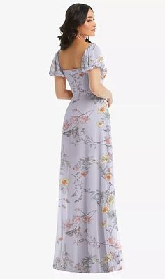 a woman in a long dress with flowers on the back, looking off to the side