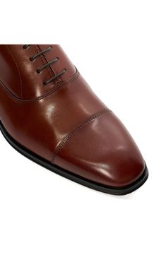 Tonal stitching subtly highlights the cap toe of a classic oxford fashioned from smooth, burnished leather. Lace-up style Leather upper/textile lining/synthetic sole Imported Cap Toe Oxfords For Derby, Fitted Cap Toe Oxfords For Derby, Fitted Oxford Derby Shoes With Almond Toe, Fitted Almond Toe Derby Shoes In Oxford, Fitted Almond Toe Derby Oxford Shoes, Fitted Almond Toe Derby Shoes, Classic Cap Toe Oxfords With Leather Sole, Fitted Plain Toe Oxford With Leather Sole, Timeless Fitted Plain Toe Oxfords