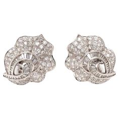 This exceptional pair of 18K white gold pave diamond earrings by Adler epitomizes timeless elegance and luxurious craftsmanship. Featuring 194 round brilliant and baguette cut diamonds totaling an impressive 7 carats, with H-I color and VS-2 clarity, these earrings radiate brilliance and sophistication. Measuring 1.25 inches long and weighing 26.5 grams, these earrings offer a substantial yet refined presence. The convertible design, with hidden posts and backs, allows them to be worn with pierc Pave Diamond Earrings, Mid Century Jewelry, Baguette Diamonds, Baguette Cut Diamond, White Gold Earrings, Fine Jewelry Collection, Baguette Diamond, Pave Diamonds, Round Brilliant