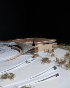 an architectural model of a building on top of snow covered ground with trees in the foreground