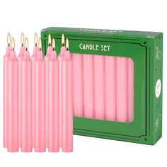 pink candles are lined up in a green box with the candle set next to it