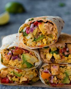 several burritos stacked on top of each other with vegetables and meat in them