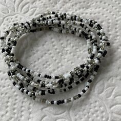 WITCHES BREW -Black and white with silver seed bead stretch bracelet set. 2mm beads. Gift for her birthday, Christmas or anytime. Gift yourself. Wear anytime, dressy or casual. Stunning set you ca wear stacked or a single bracelet. Witches Brew Mix of colors that are exceptional and will gather attention when you wear this set of 5 bracelets. Adjustable White Waist Beads With Tiny Beads, Adjustable White Waist Beads With Spacer Beads, Handmade Adjustable White Waist Beads, Adjustable White Waist Beads As Gift, Adjustable White Waist Beads For Gift, Adjustable White Waist Beads For Gifts, Adjustable Handmade White Waist Beads, White Multi-strand Beaded Bracelets As Gift, White Multi-strand Beaded Bracelets