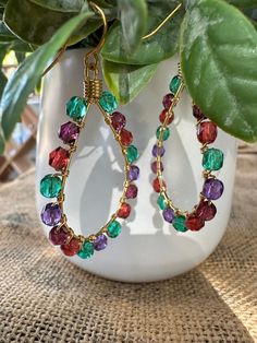 Add a pop of color to your outfit with these vibrant Gold Plated Teardrop Shape Earrings, featuring a stunning combination of green, red, and purple beads. The teardrop shape and gold plating add a touch of elegance, while the colorful beads create a playful, whimsical effect. Gold Teardrop Earrings With Colorful Beads, Multicolor Teardrop Hoop Earrings Gift, Multicolor Teardrop Hoop Earrings, Multicolor Teardrop Hoop Earrings With Dangling Beads, Party Teardrop Colorful Beaded Earrings, Multicolor Beaded Teardrop Earrings For Gift, Multicolor Teardrop Earrings With Colorful Beads For Gift, Handmade Multicolor Teardrop Earrings For Parties, Purple Beads