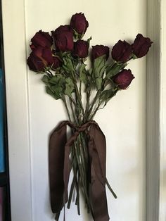 a bunch of roses tied to a wall