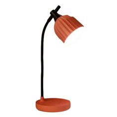 an orange table lamp with a black base and a white light on top of it