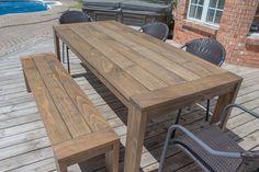 a wooden table sitting on top of a wooden deck next to a swimming pool with chairs