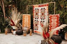 an outdoor area with potted plants, vases and decorative artwork on the ground