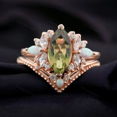 a ring with an oval cut green and white gems