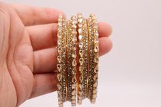 Elevate your style with a set of 4 luxurious Indian gold bangles. You can wear these to complement any outfit, whether it's to a party, wedding, or a special occasion.   Wear 4 bangles on one hand or wear 2 on each hand to add that extra wow factor.  Each bangle measures 0.25 inches. Free and fast shipping from the U.S.A! Adorn your wrists with the shimmering allure of Indian craftsmanship; these are not glass so will not break or hurt while sliding through your hand. Shop now and make a stateme Gold Stackable Bracelets For Parties, Elegant Festive Stackable Jewelry, Gold Bridal Sets For Party, Gold Plated Round Bangle For Wedding, Stackable Bangle Jewelry For Party, Adjustable Gold Bridal Sets As Gift, Adjustable Gold Bridal Sets For Gifts, Adjustable Gold Bridal Set For Formal Occasions, Party Stackable Bangle Jewelry