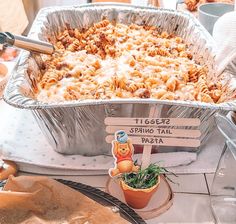 a casserole dish with pasta and spinach in it on top of a table