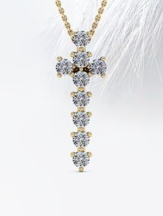 a diamond cross pendant with feathers in the background