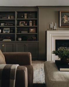 a living room filled with furniture and a fire place in front of a book shelf