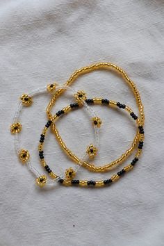 The cutest black and gold stacking set for some Saints pride. This listing is for 3 bracelets! They are made on a stretchy string for easy on and off. Gold Beaded Bracelets With Letter Beads For Festival, Adjustable Gold Stretch Bracelet For Festivals, Gold Bracelets With Spacer Beads For Festival, Handmade Flexible Gold Bracelet, Gold Handmade Flexible Bracelet, Gold Beaded Bracelets With Black Beads For Festivals, Gold Letter Beads Bracelets For Festival, Festival Gold Beaded Bracelets With Black Beads, Gold Festival Bracelets With Letter Beads