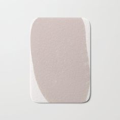 a pink and white bath mat with an oval design on the bottom, in front of a light gray background