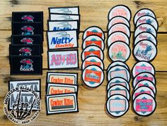 various patches and stickers are laid out on a wooden surface