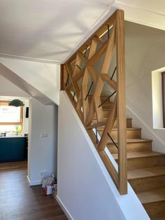 a wooden stair case next to a white wall