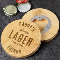 two personalized wooden coasters sitting on top of a table next to bottle openers