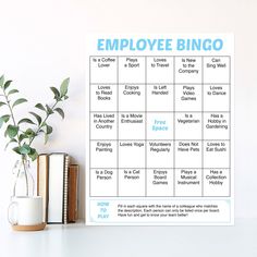 an employee's bingo game on a table next to a book and plant in a vase