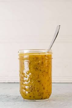 a glass jar filled with yellow sauce and a spoon