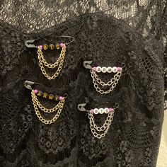 three pairs of chain and beaded earrings on a black lace dress with pink beads