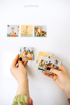 a person holding up four polaroid pictures on a white wall next to each other